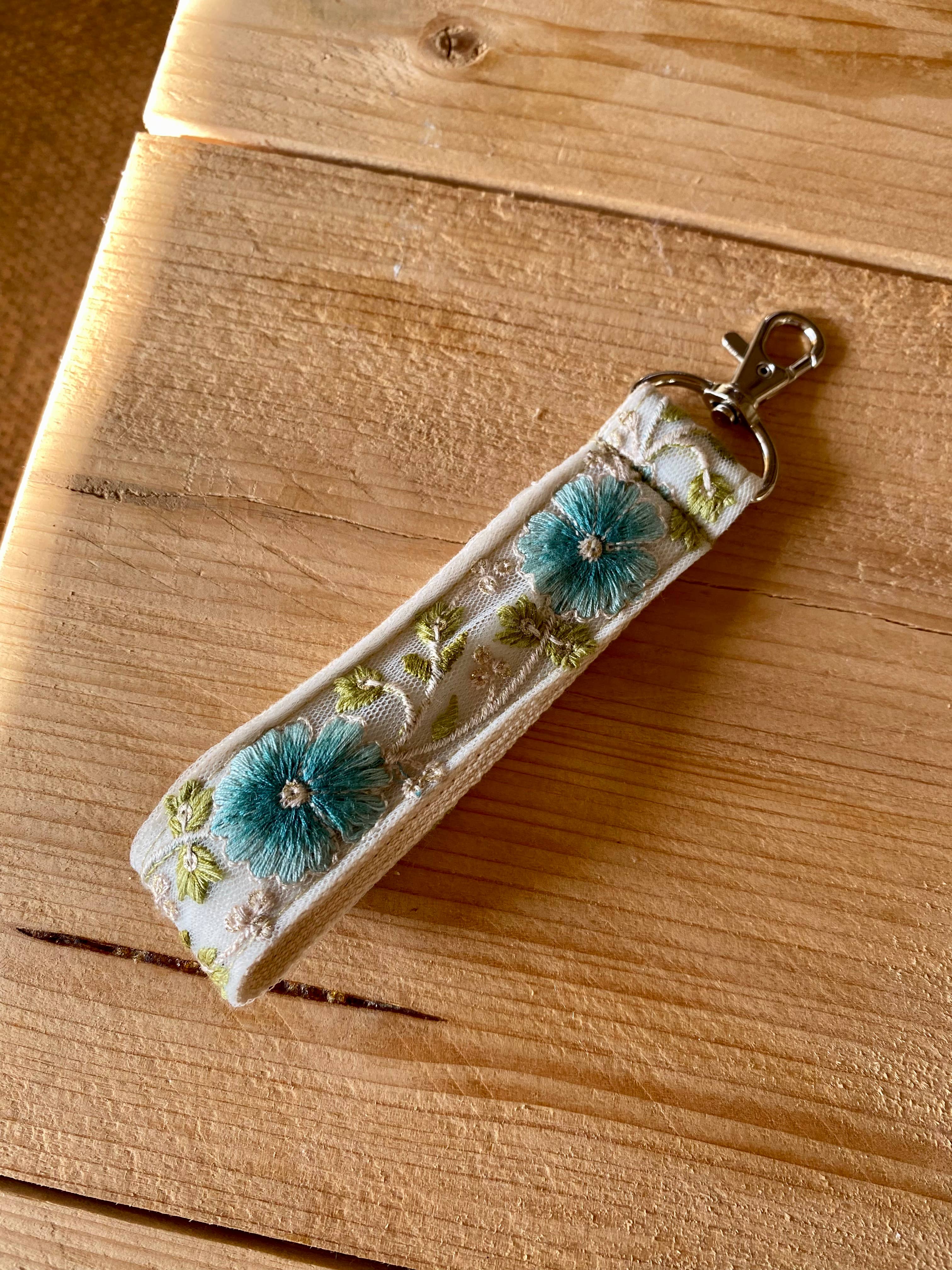 Blauer Schlüsselanhänger aus Stoff mit Blumenmuster und Haken zum Verschenken